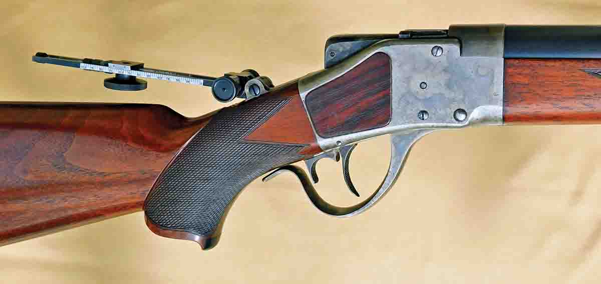 Action area of the Sharps Long Range rifle showing the adapted rear sight stem, faux rosewood action inserts, ebony pistol grip insert and excellently executed checkering.